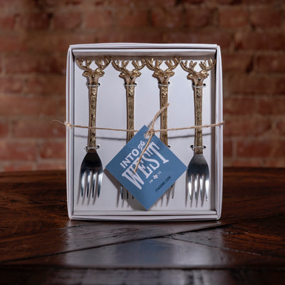 Gift-boxed gold antler handle appetizer fork set of four on rustic wood surface