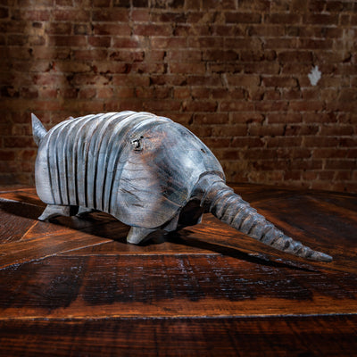 Side view of rustic wooden armadillo sculpture with detailed ridges