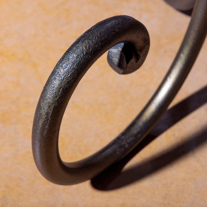 Detailed view of hand-forged iron leg with blackened bronze finish