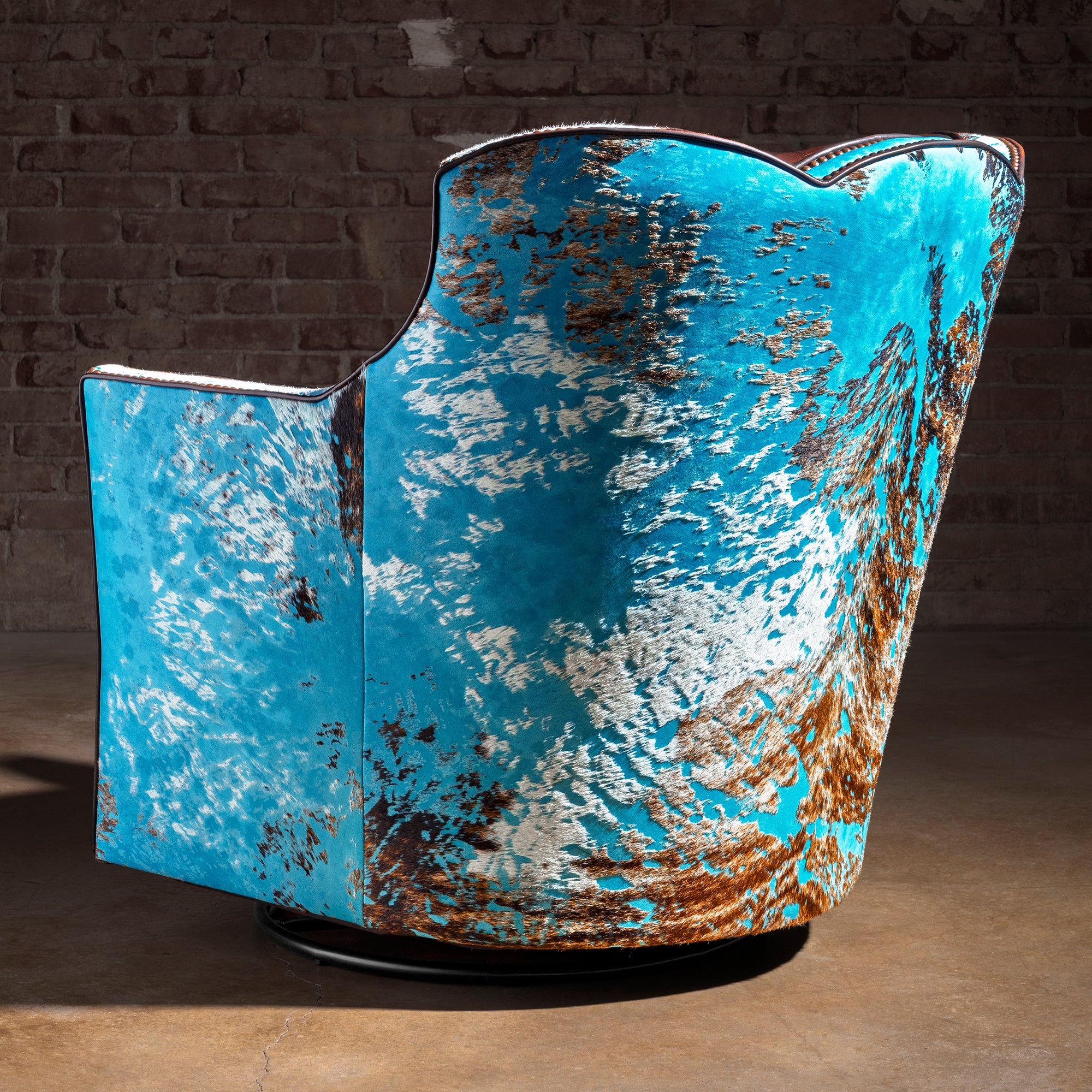 Azure Spur Tufted Western Swivel Chair western swivel chair with turquoise cowhide, leather seating, and sculpted barrel silhouette.