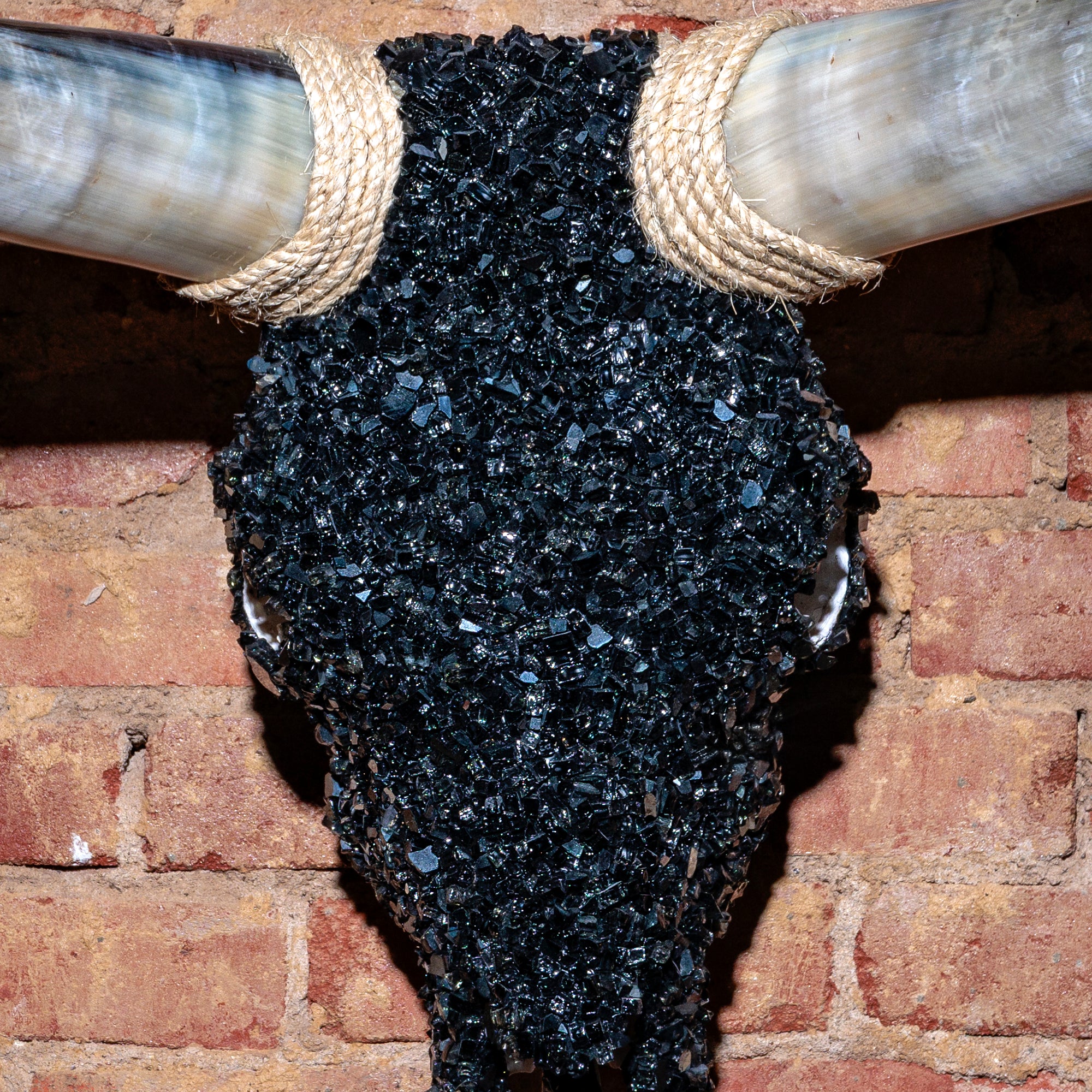 Close-up of crushed black glass texture and rope accent on bull skull wall mount