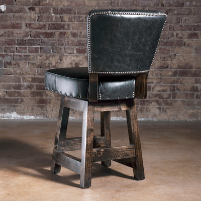Back view of black leather bar stool with nailhead-trimmed back and dark stained alder wood legs—upscale Western bar stool