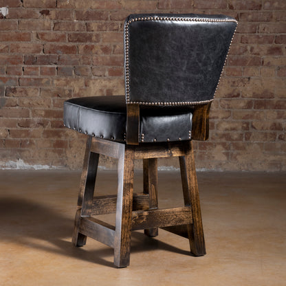 Back view of black leather bar stool with nailhead-trimmed back and dark stained alder wood legs—upscale Western bar stool