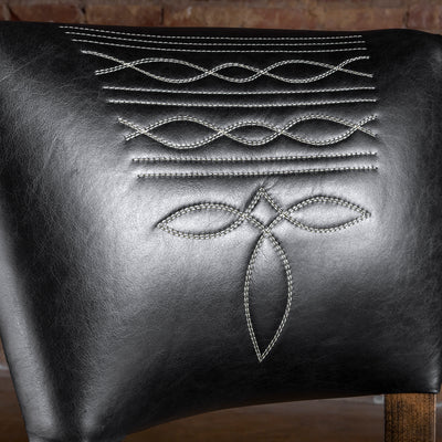 Close-up of bootstitch embroidery on black leather backrest of Western bar stool