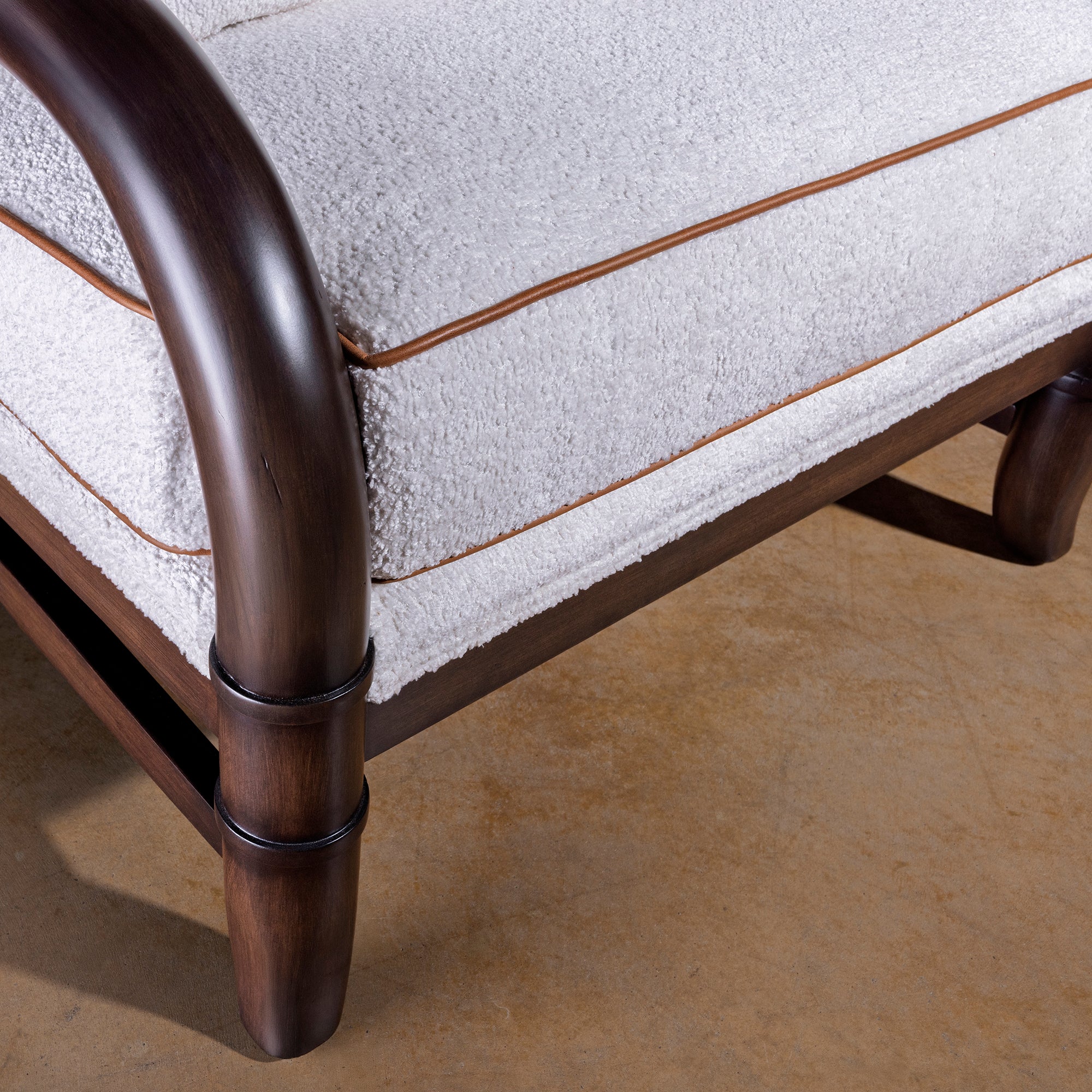 Closeup of bouclé seat cushion with leather piping on Briarwood lounge chair