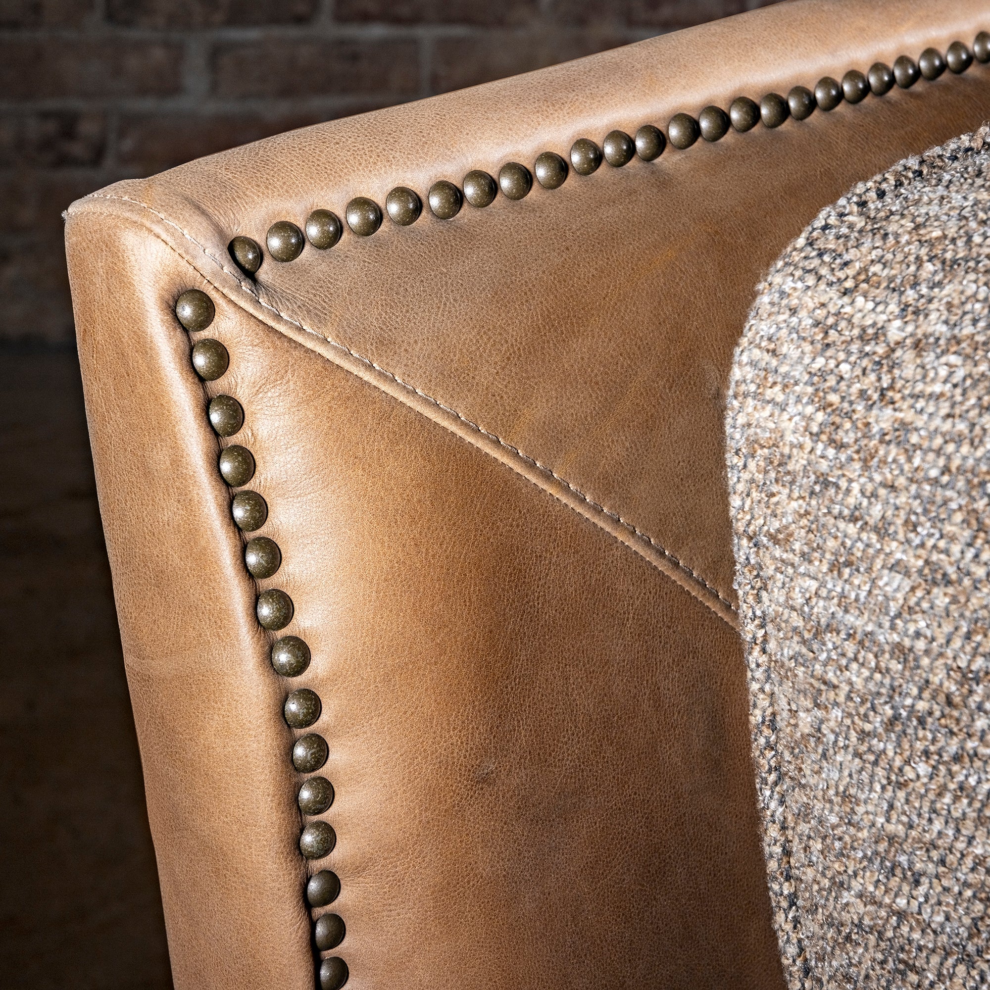 Bridger Nailhead Sofa western sofa corner detail with tan leather, nailhead trim, woven cushion, and heirloom style