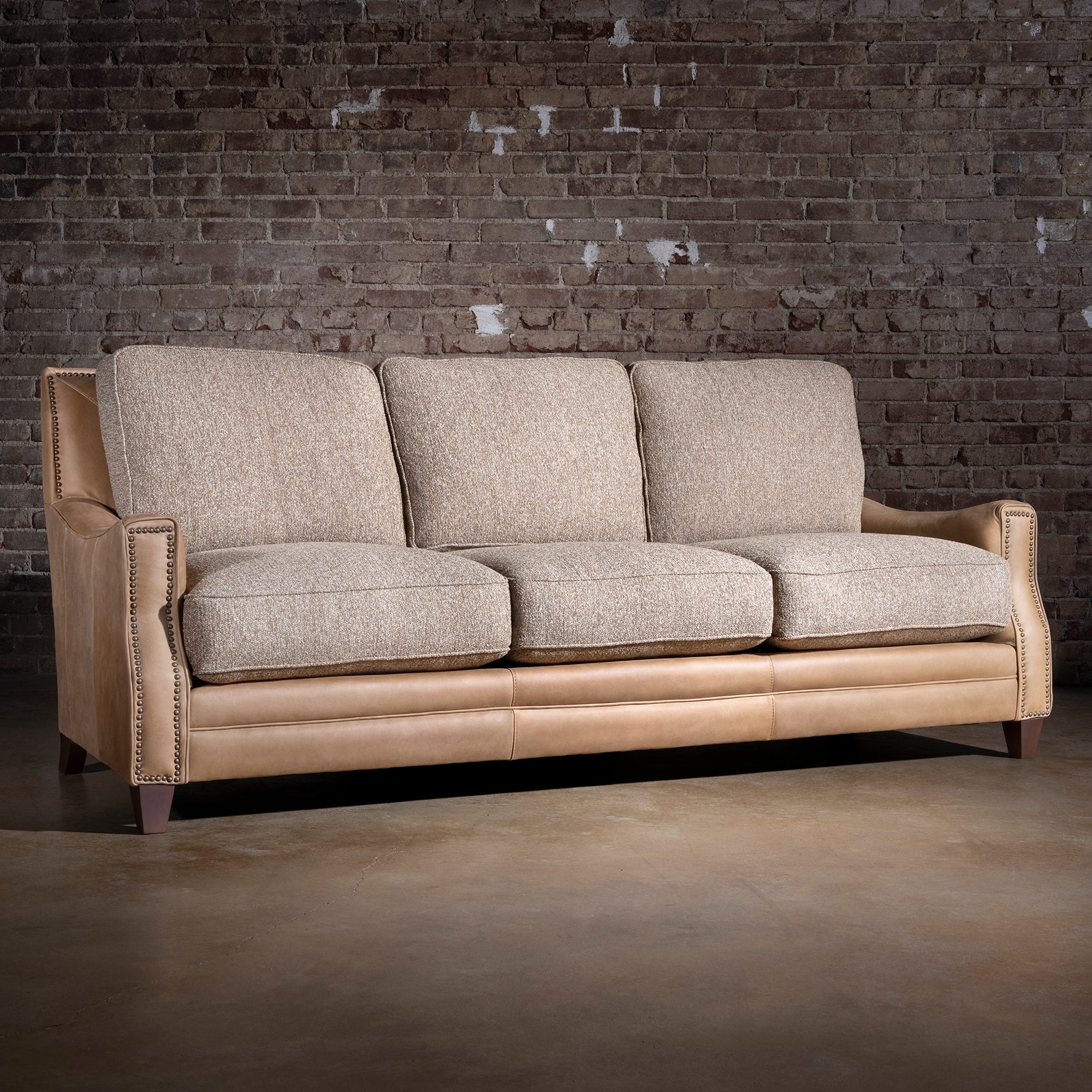 Bridger Nailhead Sofa western sofa with tan leather back, antique nailhead trim, and textured woven cushions