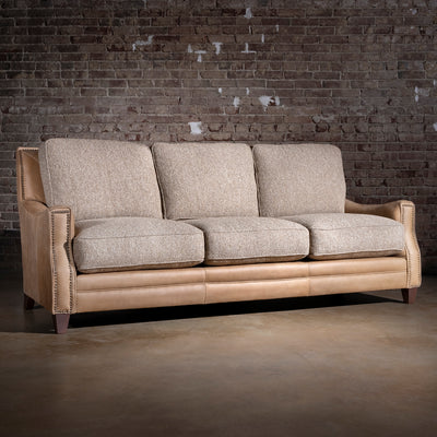 Bridger Nailhead Sofa western sofa with tan leather back, antique nailhead trim, and textured woven cushions