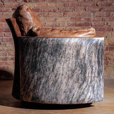 Side view of oversized cowhide and leather swivel recliner with nailhead accents