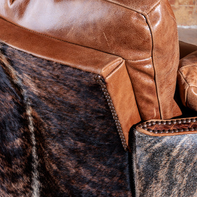 Close-up of brindle cowhide and top-grain leather on handcrafted Western chair