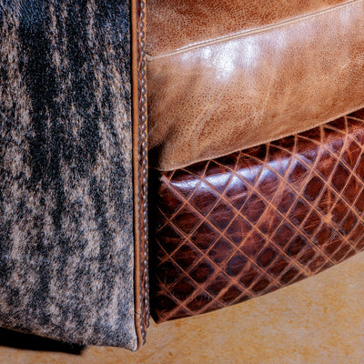 Close-up of brindle cowhide and top-grain leather on handcrafted Western chair