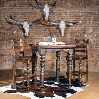 Western pub table and stools in bar scene with longhorn skull wall décor.