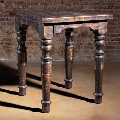 Western reclaimed wood pub table with turned legs in studio setting.