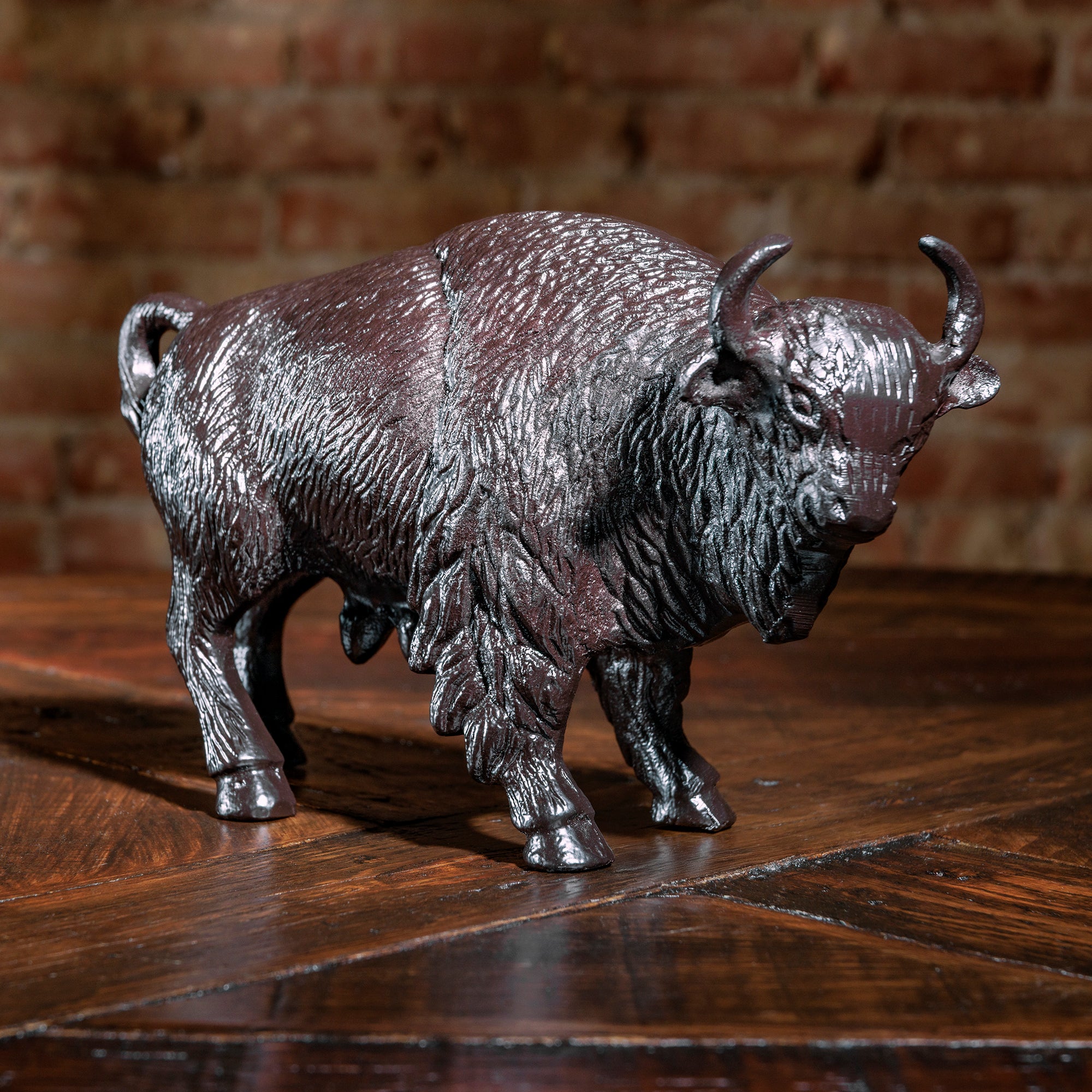 Cast iron buffalo sculpture on rustic wood surface