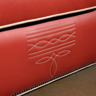 Closeup of bootstitch-inspired embroidery on coral-red leather chair front panel