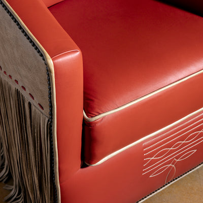 High-angle closeup showing smooth leather, piping, and refined upholstery finish