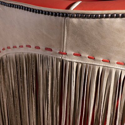 Back view showing taupe leather panel, red lacing, and full fringe on swivel chair