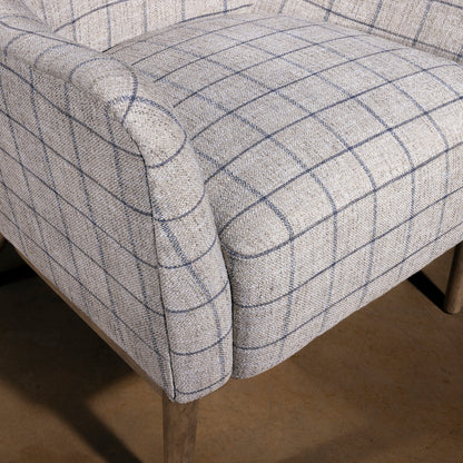 Close-up of upholstered seat and arm on windowpane fabric chair, lodge-style ranch chair cushion and weave detail