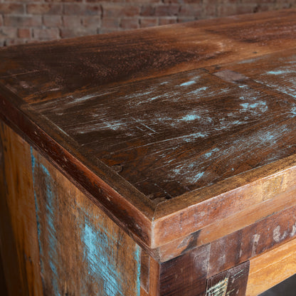Corner close-up of reclaimed wood buffet top showing distressed turquoise accents, luxury Western furniture detail