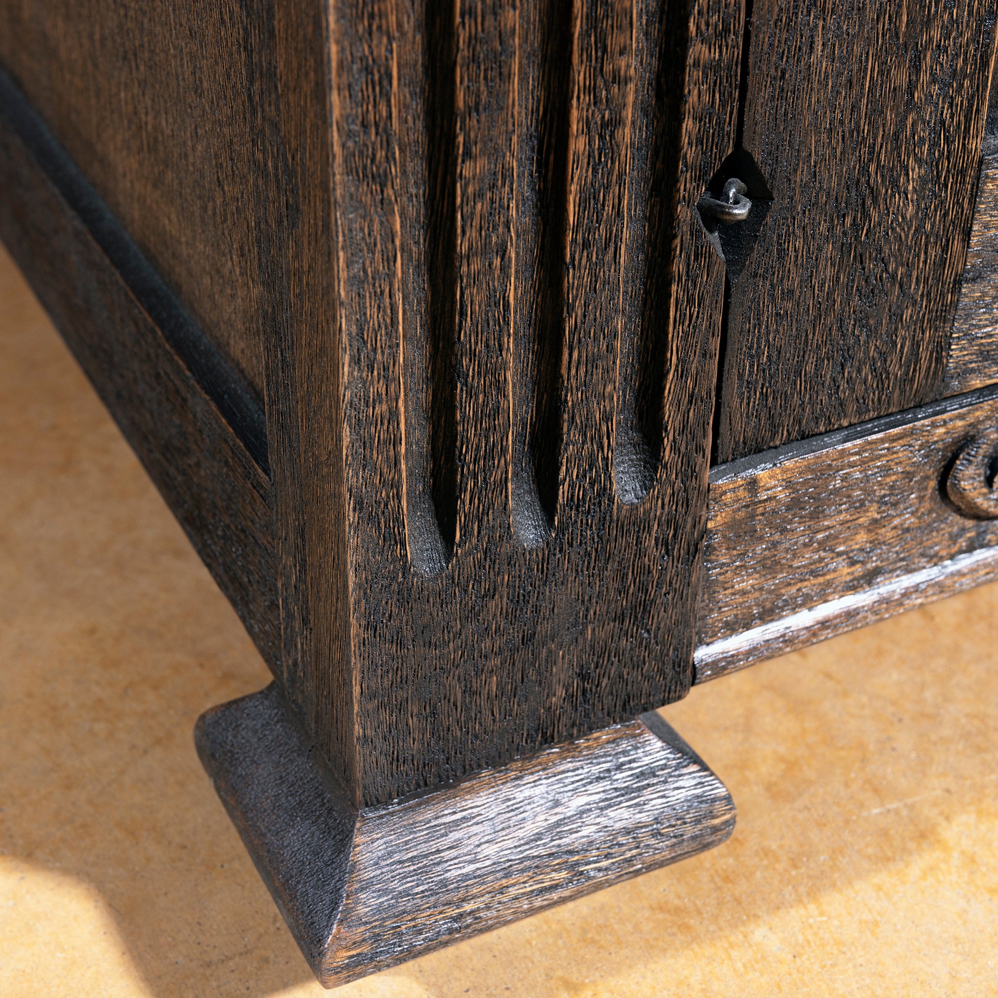 Western nightstand foot detail in antique dark wood with carved base and rustic ranch bedroom style