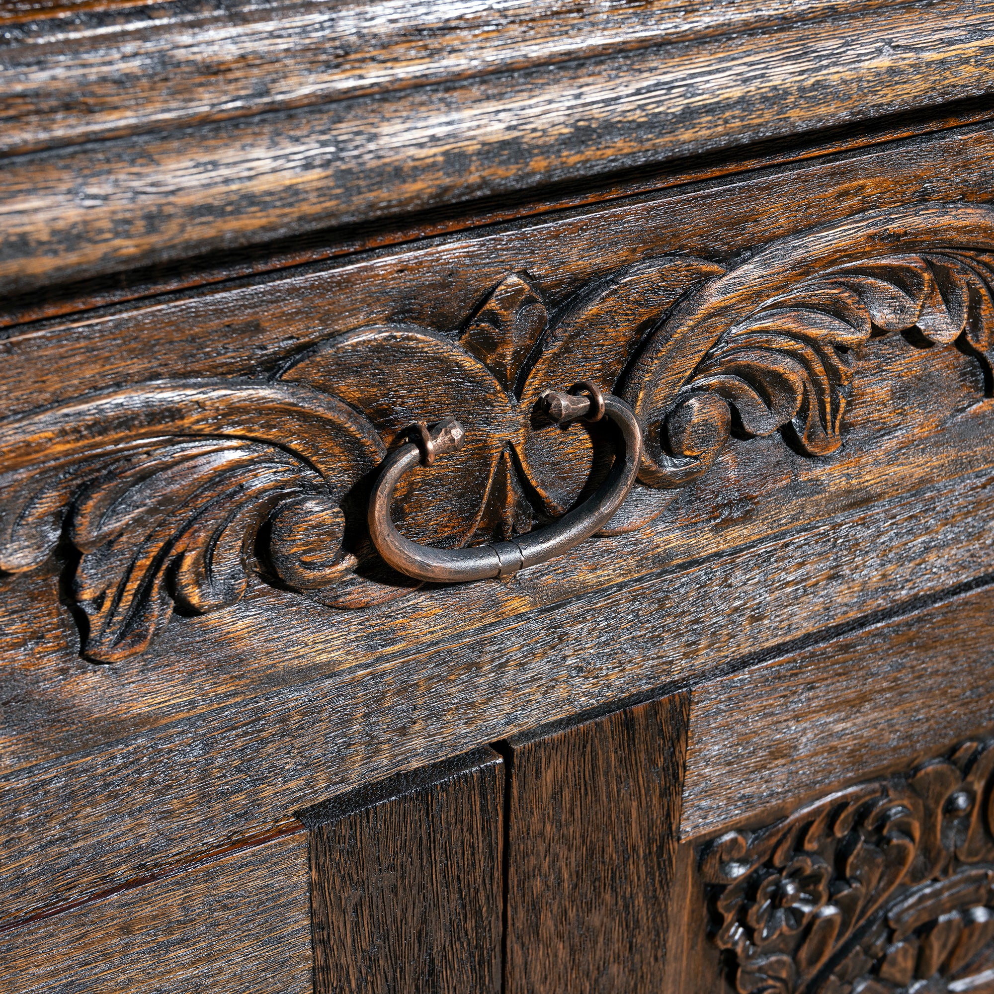 Forged iron ring pull hardware closeup on carved Western nightstand with antique metal finish