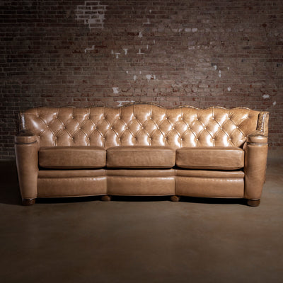 Front view of tufted top-grain leather Western sofa with scalloped back silhouette