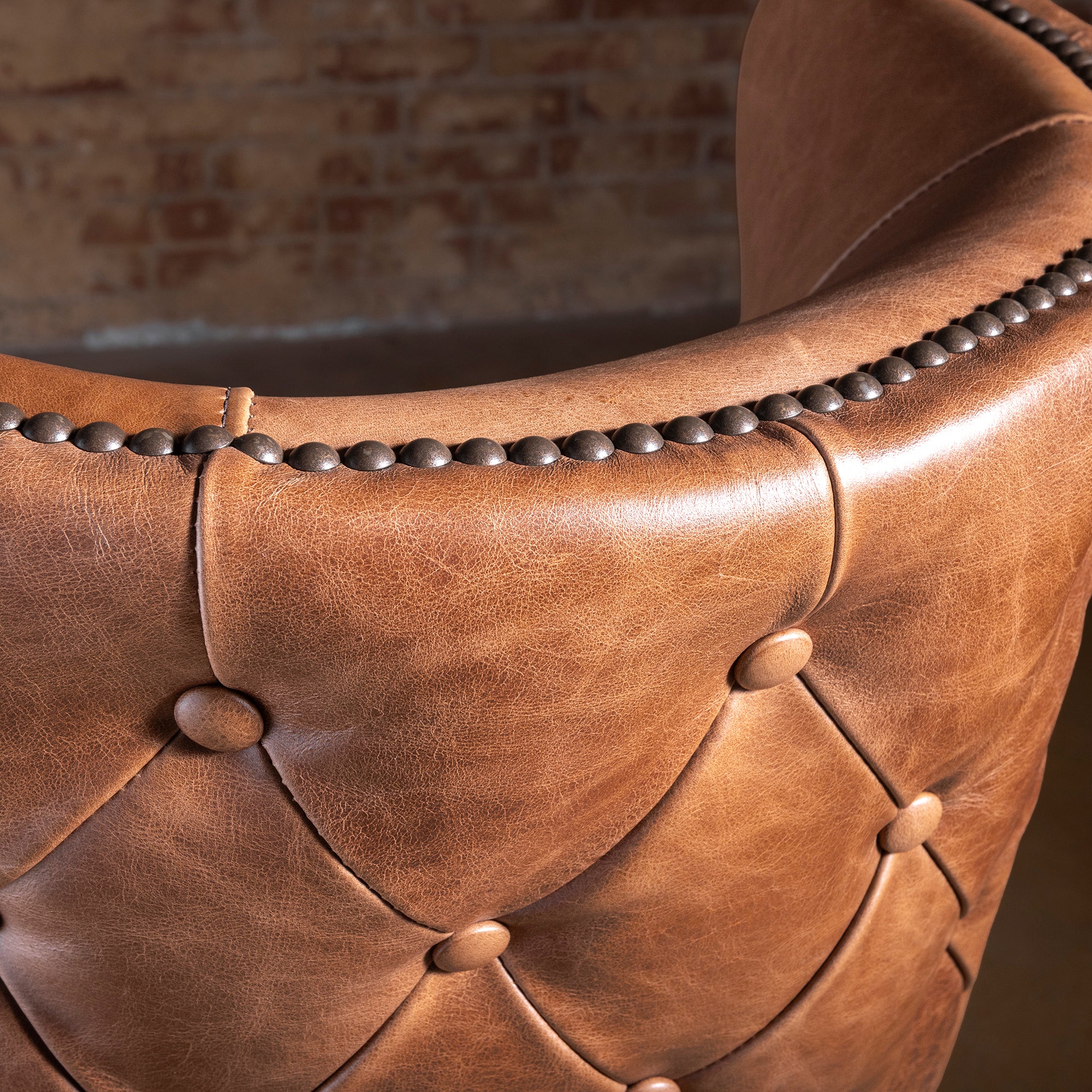 Closeup of Catalina bar stool button tufting and nailhead trim on curved leather back
