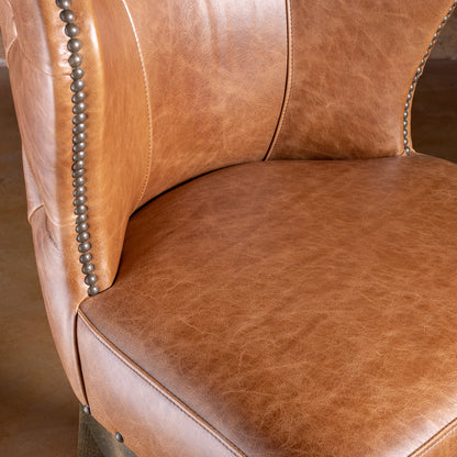 Detail of Catalina bar stool seat and curved back showing leather paneling and refined silhouette