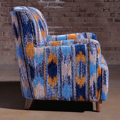 Side profile of compact upholstered accent chair in cerulean Southwestern pattern