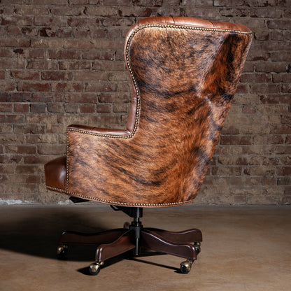 Back view of Western cowhide office chair with solid wood frame, nailhead trim, and caster base