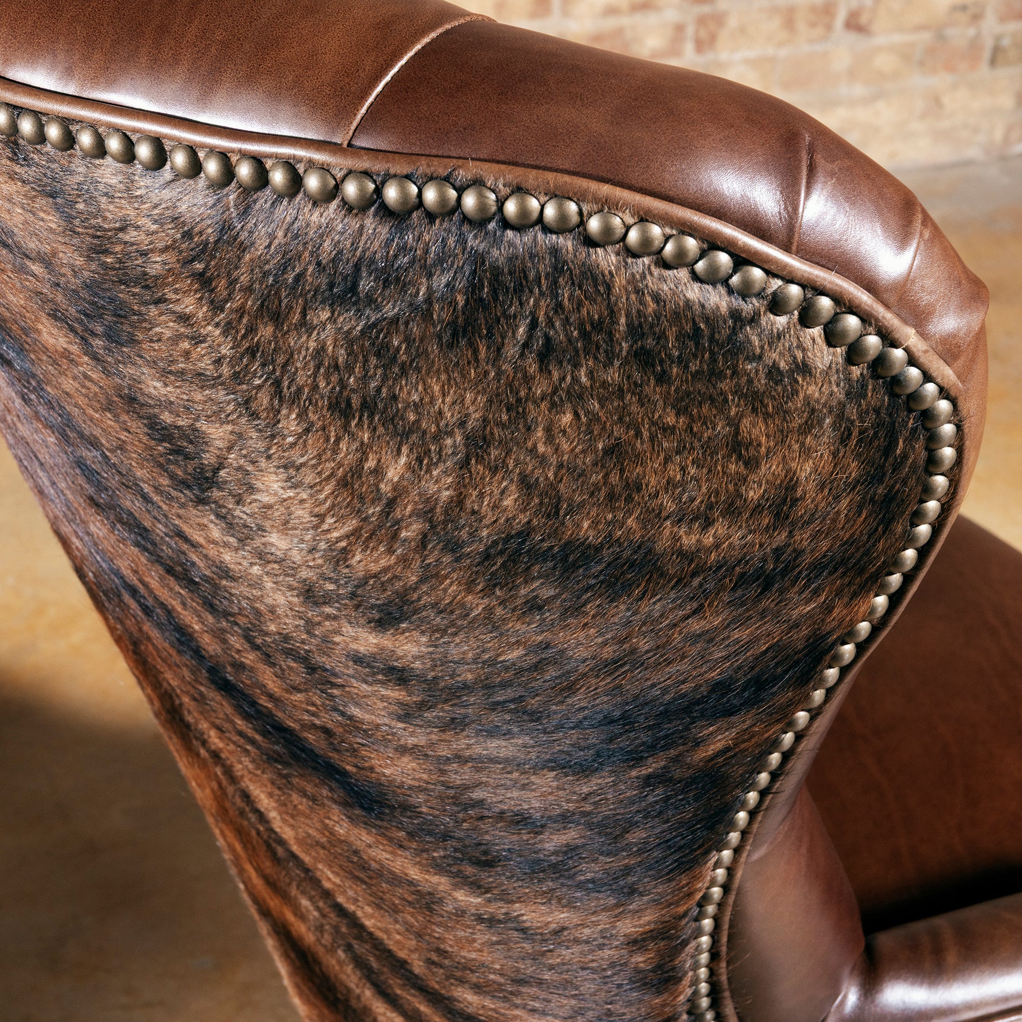 Back view of Western cowhide office chair with solid wood frame, nailhead trim, and caster base