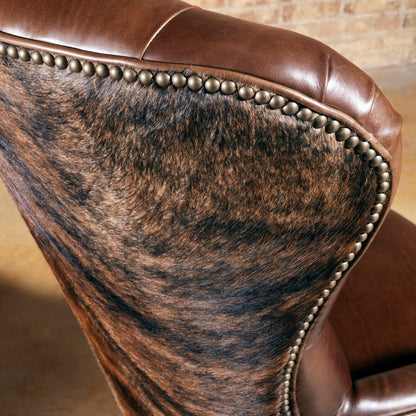 Back view of Western cowhide office chair with solid wood frame, nailhead trim, and caster base