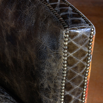 Hand-applied nailhead trim on distressed leather armrest