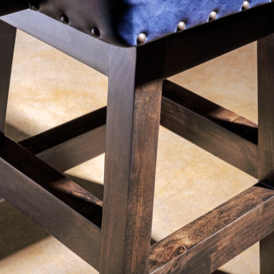 Cobalt Mesa Bar Stool western bar stool base detail with dark wood frame, stretcher support, and tailored leather seat.