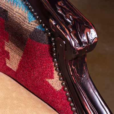 Carved wood arm detail with nailhead trim on Western accent chair