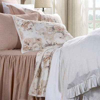 Bed styled with Colette blush floral quilt and two matching shams, featuring diamond quilting for a soft French country look.