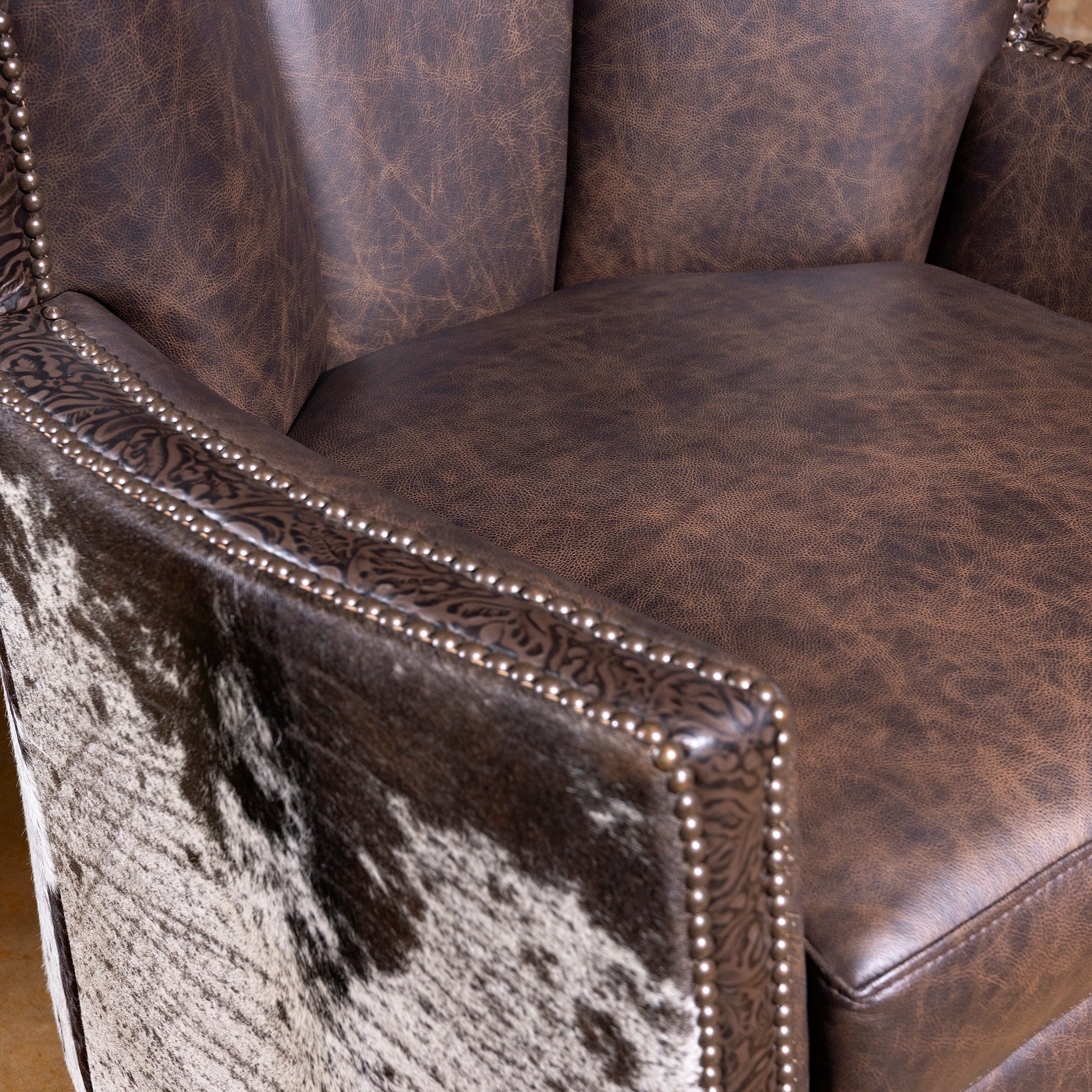 Close-up of Conch Canyon Swivel Chair arm, leather seat, and tooled trim detail
