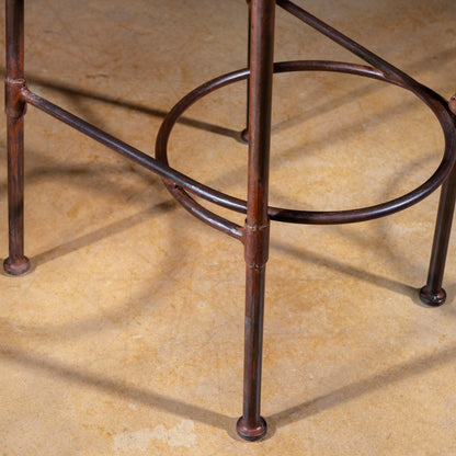 Close-up of forged iron legs and circular footrest ring on Western bar stool