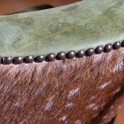 Close-up of sage-green leather western bar stool with axis hide on Coronado Axis Bar Stool