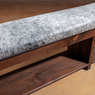 Side profile of long cowhide bench with open lower wood shelf