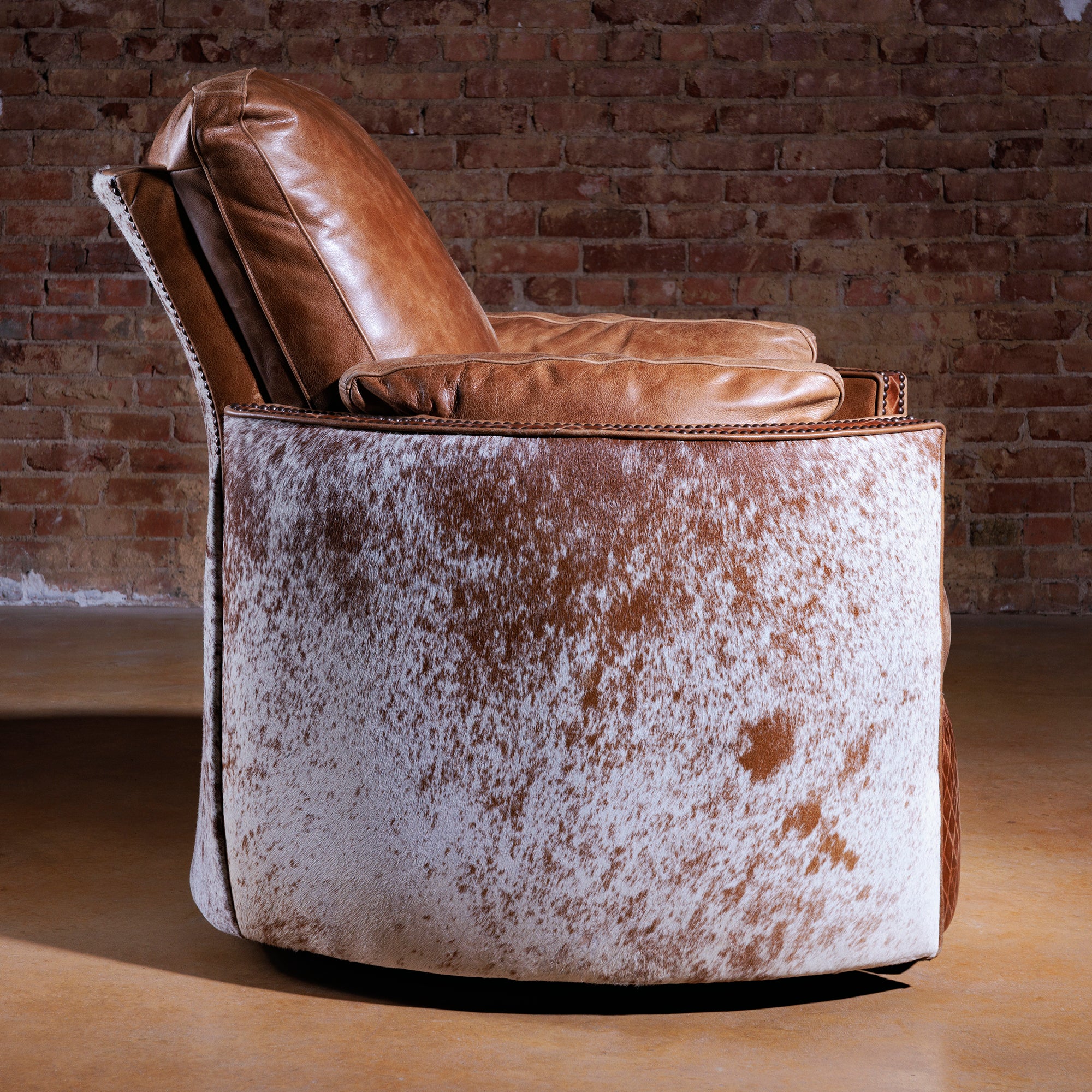 Profile view of Brazos Cuddler Recliner in cowhide and leather