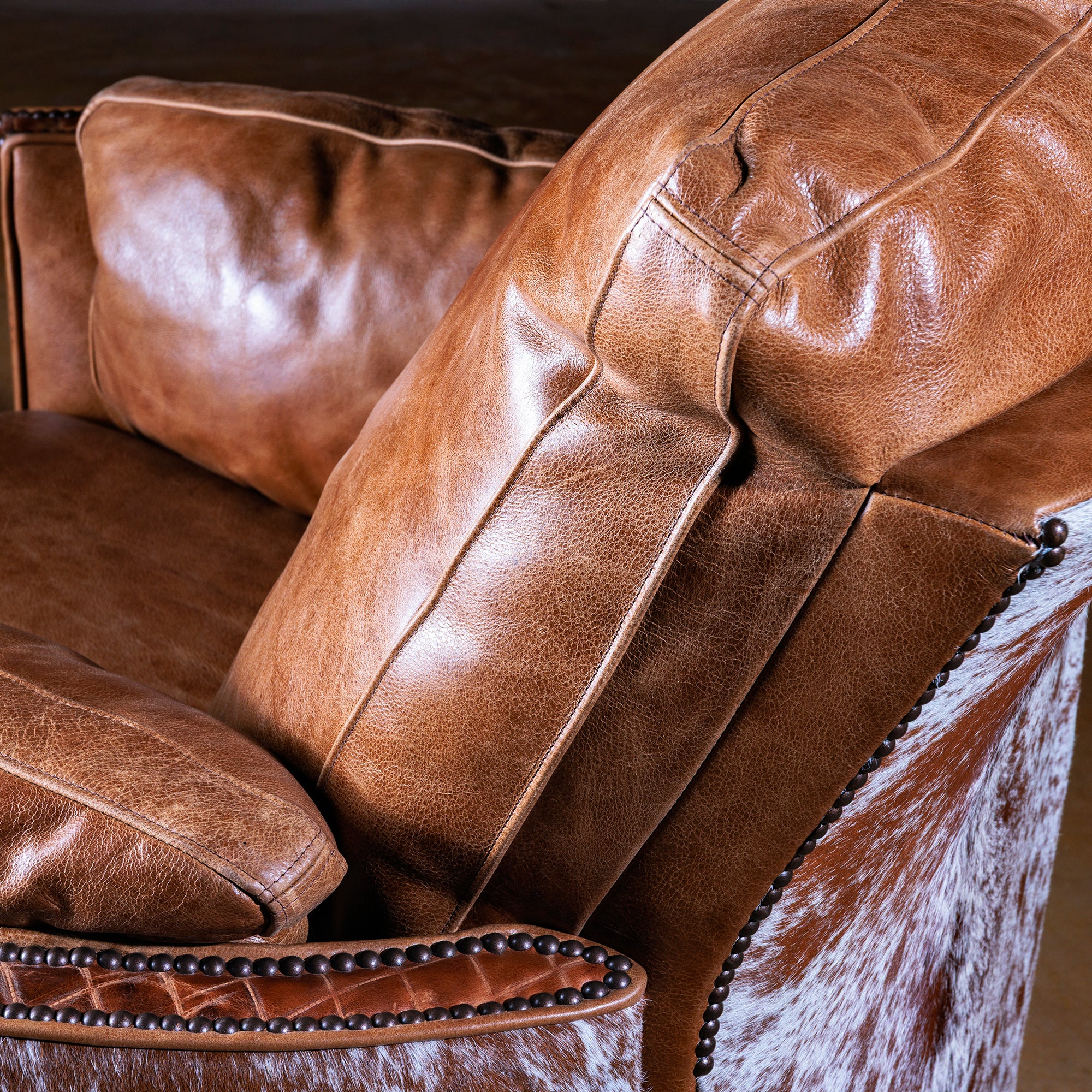 Cowhide back panel and leather detail on Western cuddler recliner