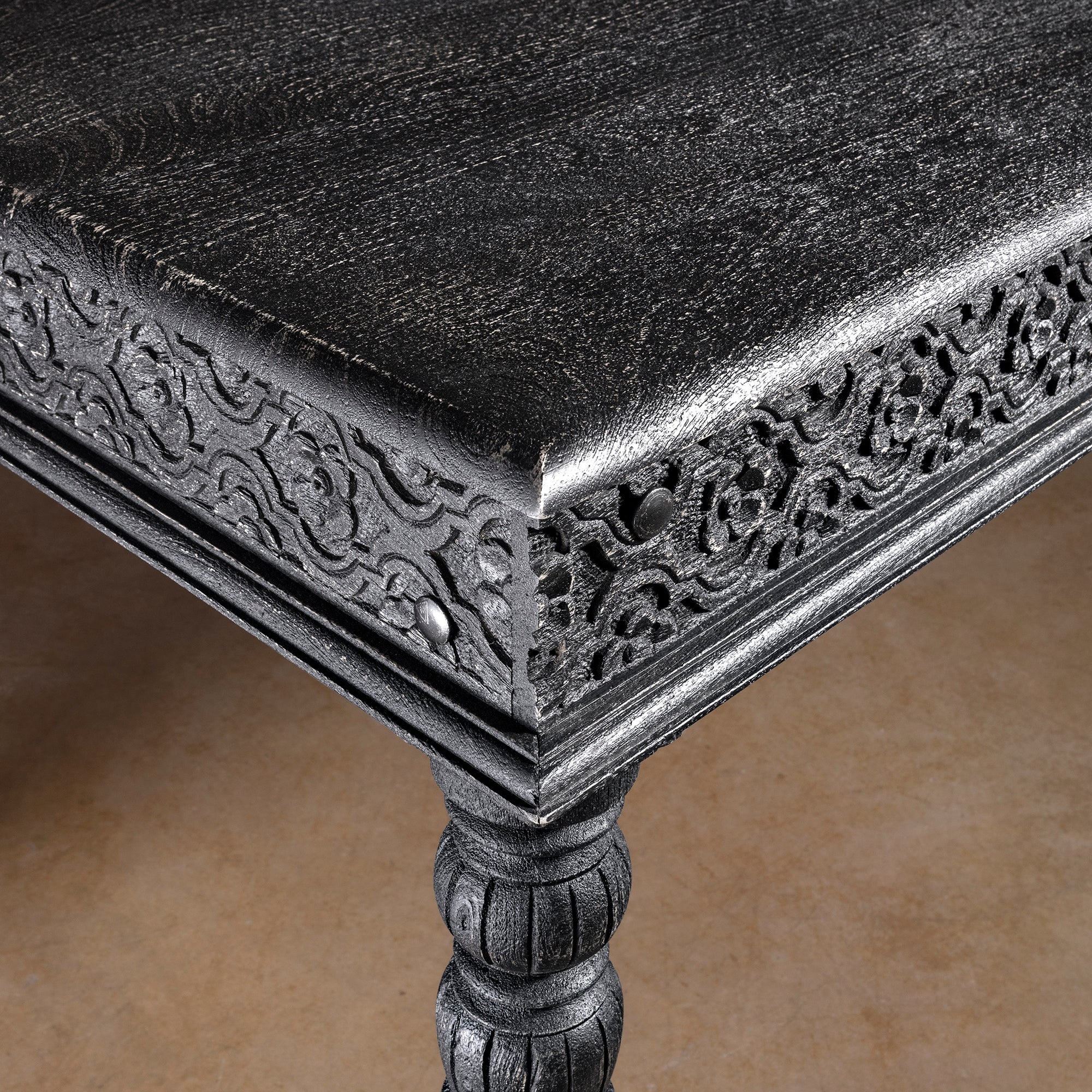 Fortville Carved Dining Table western hand carved dining table close-up with carved corner apron, black finish, and mango wood top