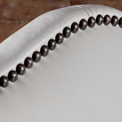 Nailhead trim along arched ivory leather back of High Plains Ivory Western dining chair