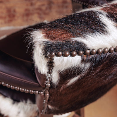Back view of the High Plains Luxe Swivel Stool, a Western swivel stool with tricolor cowhide and brown leather—ideal for a kitchen island or bar setup.