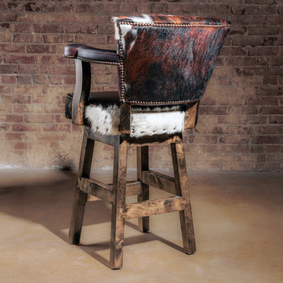 Back view of the High Plains Luxe Swivel Stool, a Western swivel stool with tricolor cowhide and brown leather—ideal for a kitchen island or bar setup.