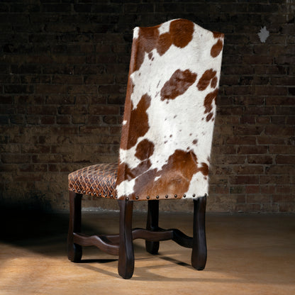 Rear view of Western dining chair showing Brazilian cowhide backrest, nailhead trim, quilted leather seat, and stained wood base for ranch dining rooms