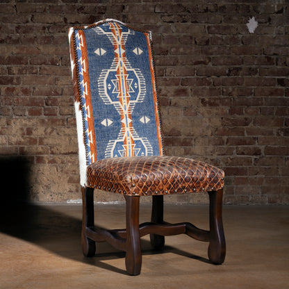 High-back Western dining chair with blue Southwestern woven fabric, quilted leather seat, nailhead trim, and dark wood legs in luxury ranch style