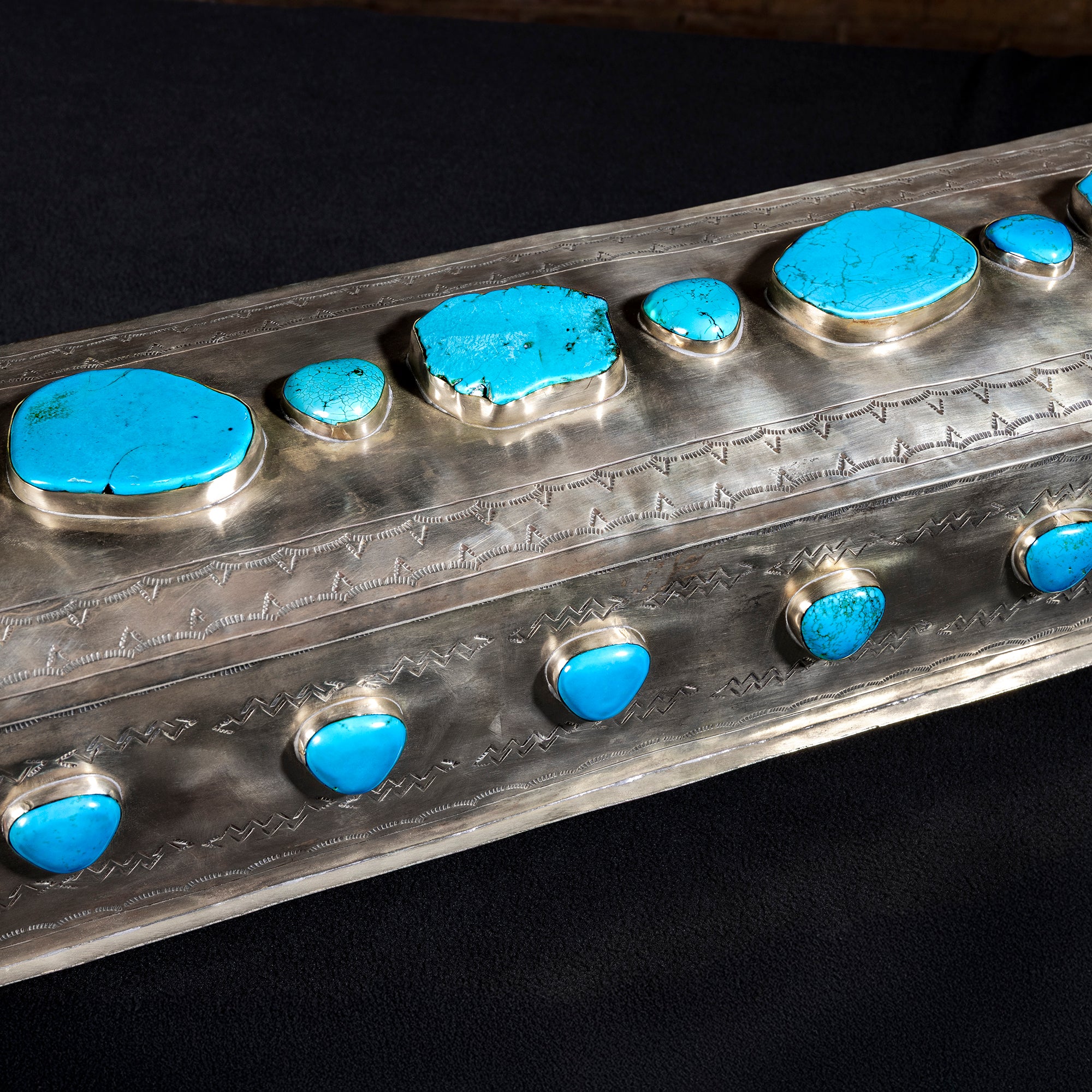 Close-up of turquoise stones on hand-tooled German silver surface of J. Alexander High Mesa Vault
