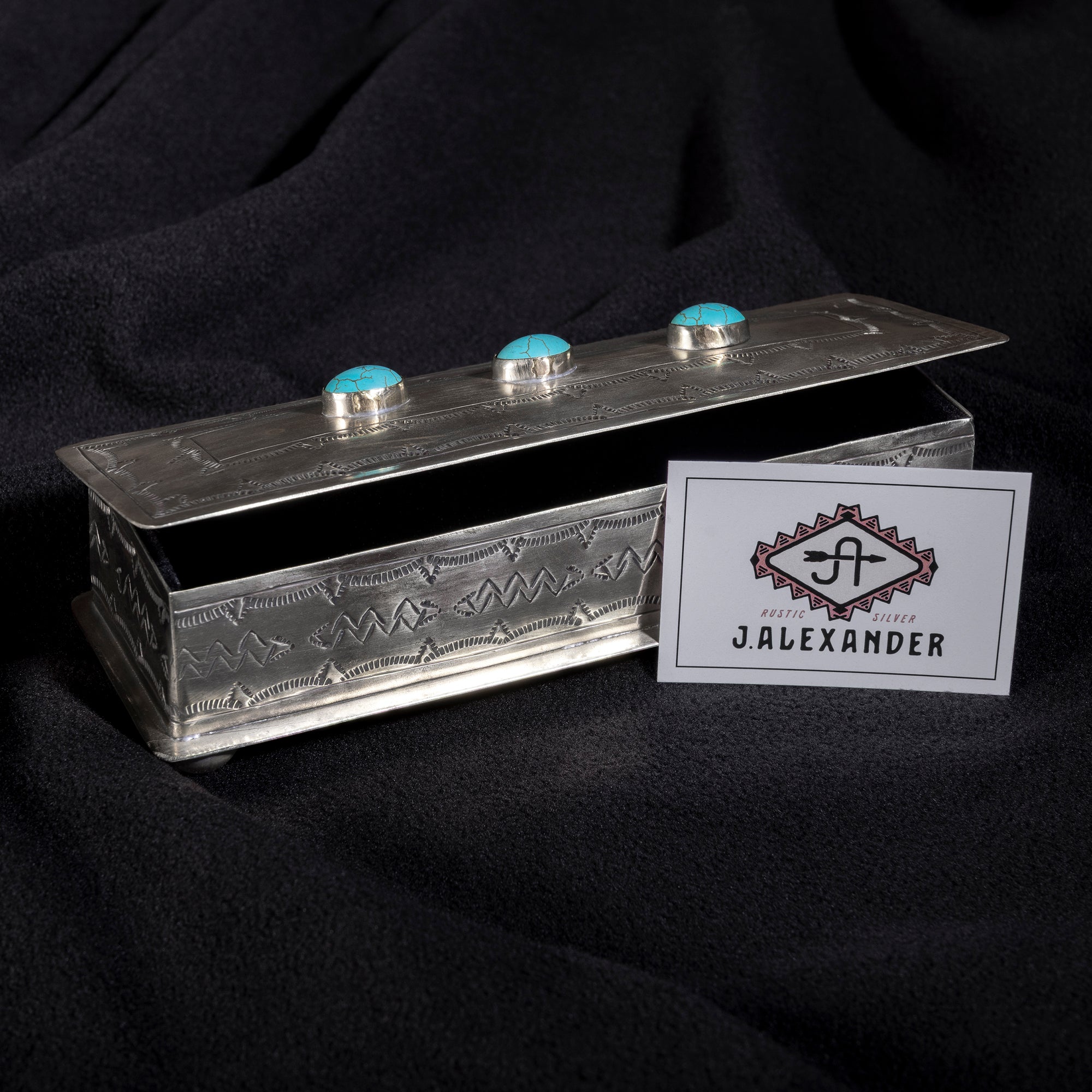 Open J. Alexander turquoise eyeglass box showing velvet-lined interior and hand-tooled silver craftsmanship